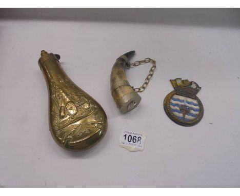 A brass powder flask, a horn wall hanging and a Bulwark plaque.