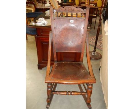 A late Victorian oak rocking chair with poker work seat and back, COLLECT ONLY.