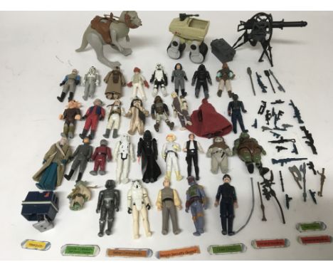 A collection of vintage Star wars figures with a collection of weapons, also including minirig and closed belly Tauntaun