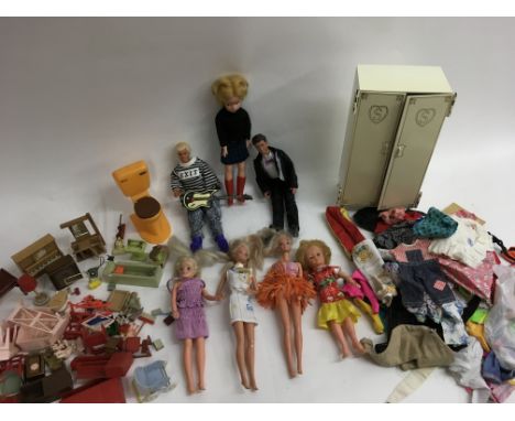 A box containing fashion dolls including Sindy plus various clothing , some labelled, and vintage  doll's house furniture inc