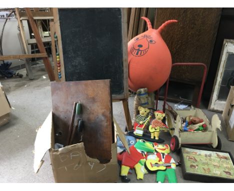 A collection of toys including a space hopper , a push along horse , a blackboard and eisel, etc