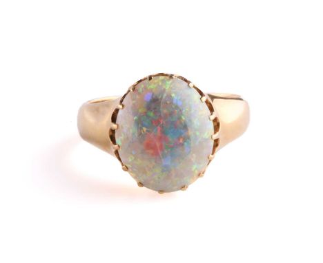 A precious opal dress ring in 18ct yellow gold, composed of an oval precious opal cabochon, approximately measures 14.5 x 12.