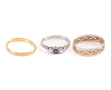 Three gold rings; including a 22ct yellow gold distorted wedding band, Birmingham hallmarked '22', 1949, size K½; a sapphire 