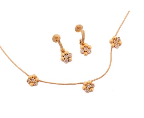 A diamond set matching necklace and earrings; the necklace comprising three, three stone diamond flower head clusters set alo