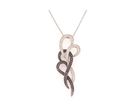A white and black diamond pendant on chain, of scrollwork design, white and black oxidised mount, with white trace link chain