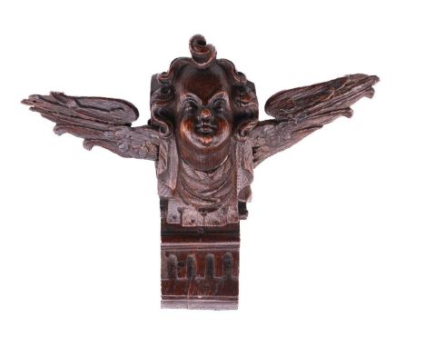 A carved oak winged putto mask wainscott bracket, late 17th century, mounted on a short section of dentil moulded cornicing.2