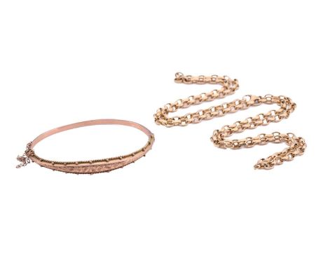 An Edwardian 9ct gold hinged bangle and a 9ct gold chain; the bracelet contains a hollow band with a panel engraved with foli