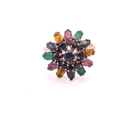 A gem-set flower dome ring, centred with a tiered cluster of circular-cut sapphires, surrounded by a skirt of navette-shaped 