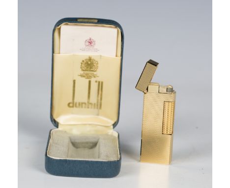 A Dunhill gold plated rectangular gas lighter, with engine turned decoration, length 6.3cm, together with directions booklet,