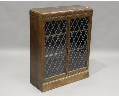 A 20th century oak bookcase with leaded glass doors, on a plinth base, height 102cm, width 82cm, depth 29cm.Buyer’s Premium 2