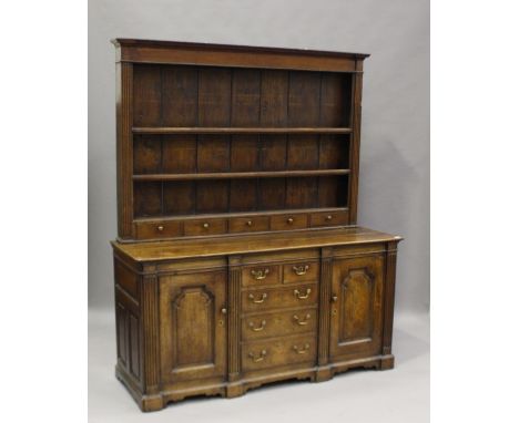 A late 18th century oak dresser, the shelf back above a central bank of drawers, flanked by arched panel doors, height 205cm,