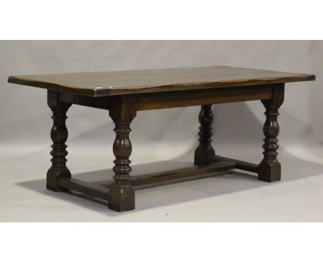 A 20th century Jacobean Revival oak refectory style dining table, raised on turned and block legs united by an 'H' stretcher,