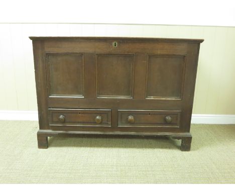 An antique oak Mule Chest with hinged lid, three panel front above two drawers on bracket supports, 4ft 2in W