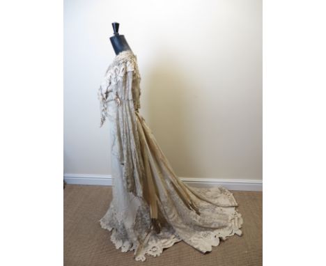 A very ornate cream woollen dress with appliqué and cut work decoration. The mainly lace bodice and sash ornamented with meta