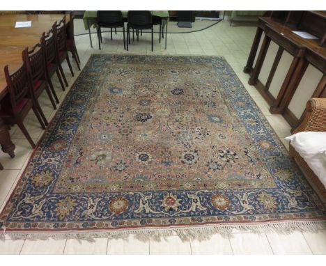 A bordered Persian Carpet with floral design on a blue and camel ground, 12ft 3in x 9ft