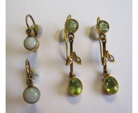 A pair of Peridot and Seed Pearl Earrings each millegrain-set circular-cut stone above leafage plaque set two seed pearls sus