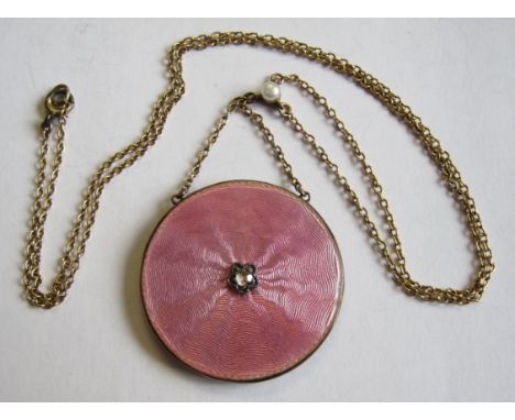 An Enamel and Diamond Locket the circular plaque with pink guilloche enamel and central rose-cut diamond on fine chain