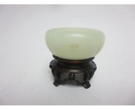 A small jade oval Bowl carved central flower, 2in, on hardwood stand