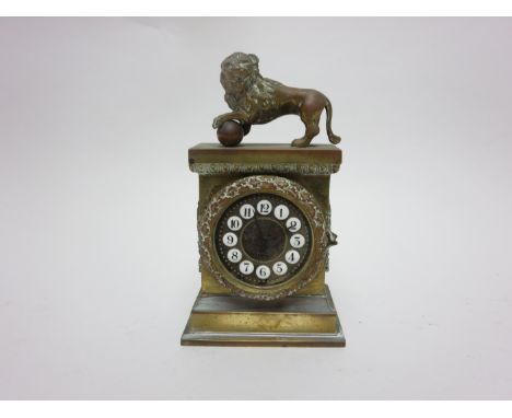 A small French style brass cased Mantle Clock with white enamel numerals within laurel wreath, lion surmount, 6in