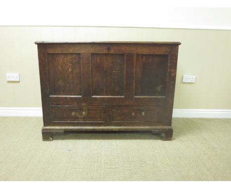An antique oak Mule Chest with hinged lid above three panel front and two drawers on bracket supports, 3ft 11in W