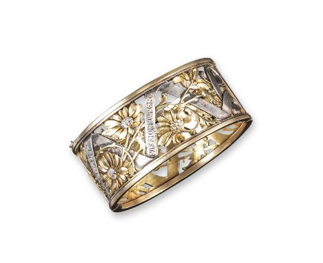 An early 20th century French silver and gold hinged bangle, pierced with realistically formed flowers, possibly daisies and w