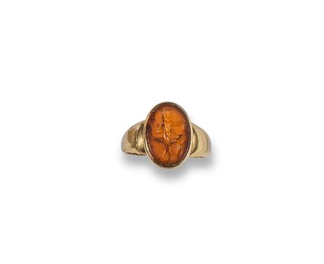 A small carnelian intaglio mounted gold ring, the intaglio possibly Roman and depicting a hunter with a child. Size J.