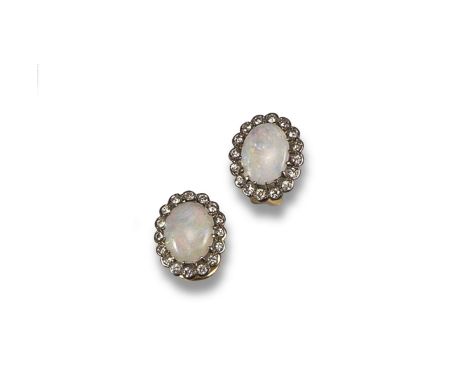 A pair of opal and diamond cluster earrings, centred with an oval~shaped opal cabochon within a surround of circular~cut diam