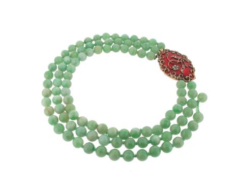 A three row jade bead necklace, with a diamond and enamel gold plaque clasp. 39cm. 