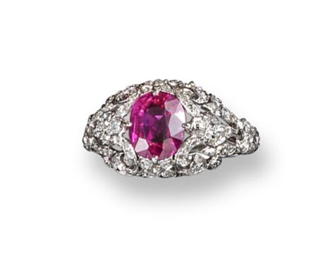 An early 20th century Burmese ruby and diamond ring, the oval~shaped ruby weighs 1.968 carats and is set with small diamonds 