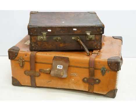 Two vintage leather bound storage trunks to include a large orange leather trunk and a smaller leather suit case, both with l