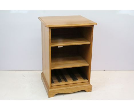 Ercol oak music cabinet with two open shelves above pull out shelf mounted with cassette holders, 82cm high x 56cm wide x 52.