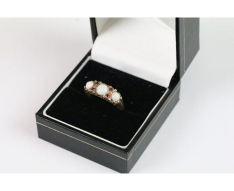9ct gold three stone opal ring, set with four red stones with chased shoulders, boxed