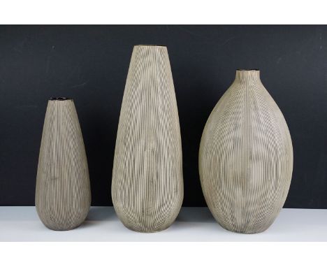 Trio of ceramic neutral grooved vases in varying shapes, Tallest 34cm