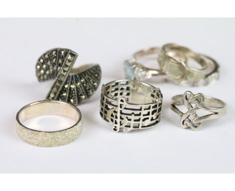 Seven silver rings including a hallmarked ring in the form of a buckle, marcasite dress ring, textured ring and a ring with p