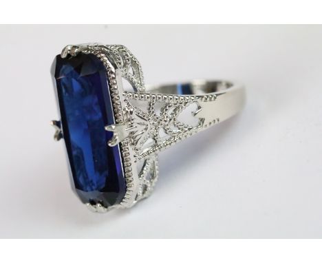 A ladies silver dress ring with central blue stone, marked 925 to the shank.