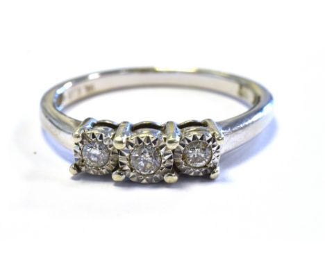 9CT WHITE GOLD DIAMOND THREE STONE RING with three illusion set round brilliant cut diamonds, reported to total 0.15 carats. 