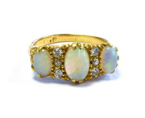 EDWARDIAN OPAL &amp; OLD CUT DIAMOND RING set with solid white opal oval cabochons, with a good play of colour, flanked by ol