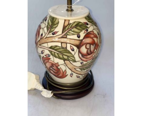 Moorcroft table lamp with floral design on ivory ground.