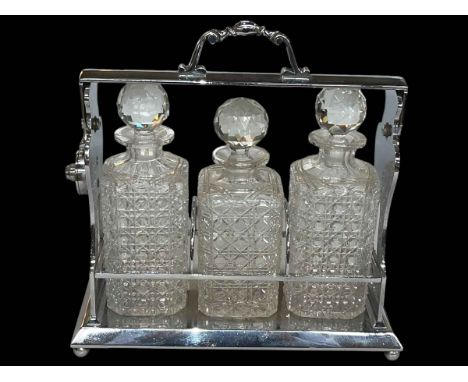 Silver plated three bottled tantalus, 34cm.