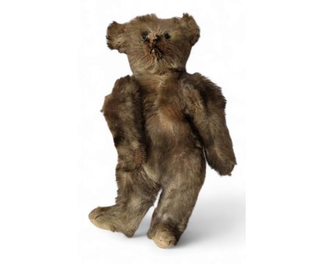 An early 20th century mohair bear, pointed snout, button eyes, small ears, jointed legs, felt pads, 21cm high, c.1910