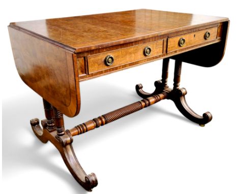 A Regency style walnut sofa table, crossbanded top, drawers to frieze, twin wrythern fluted supports with wrythern stretcher,