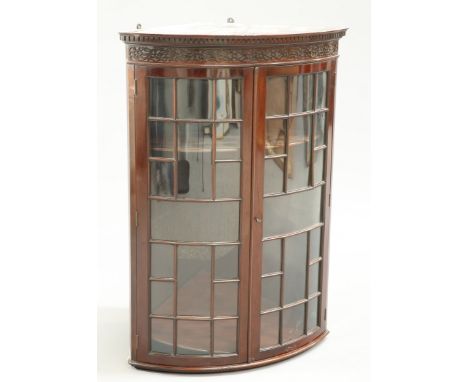 A VICTORIAN CHIPPENDALE STYLE MAHOGANY BOW-FRONTED HANGING CORNER CABINET, with dentil cornice and blind fretwork carved frie