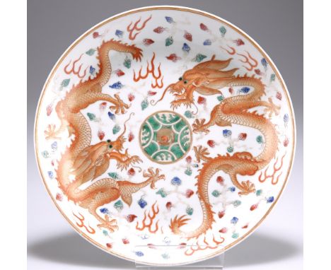 A CHINESE PORCELAIN 'DRAGON' DISH, circular, iron red painted and gilded with opposing five-claw dragons, the reverse further