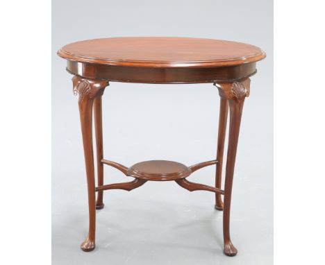 AN EDWARDIAN MAHOGANY OCCASIONAL TABLE, the moulded oval top raised on shell capped cabriole legs, joined by an X-form shelf 