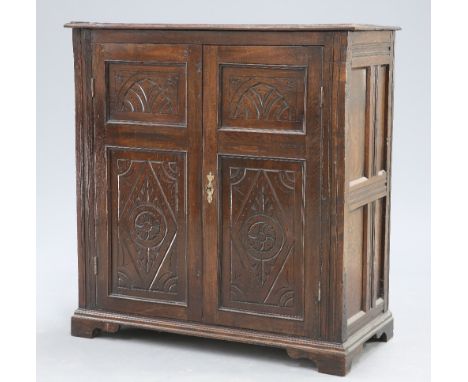 AN 18TH CENTURY AND LATER OAK CABINET, fitted with a pair of two-panel doors, carved with lozenges and lunettes, raised on br