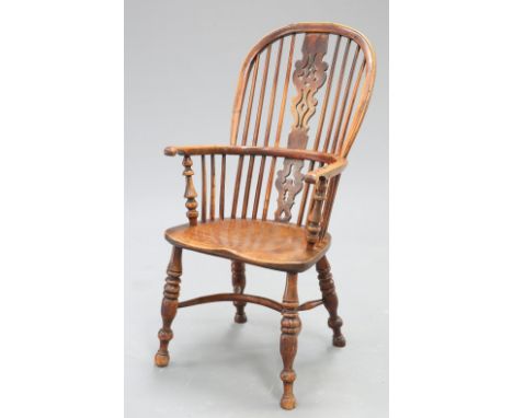 A 19TH CENTURY YEW WOOD AND ELM WINDSOR ARMCHAIR, the high back with pierced splat, raised on ring turned baluster legs joine