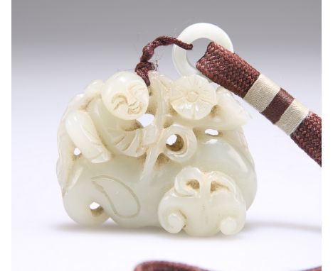 A CHINESE PALE CELADON JADE PENDANT, pierced and carved with a figure amidst foliage issuing from rockwork. 5cm wideThe absen
