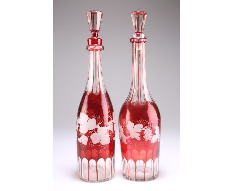 A PAIR OF BOHEMIAN RUBY FLASHED GLASS DECANTERS AND STOPPERS, each decorated with fruiting vine. 34.5cm high