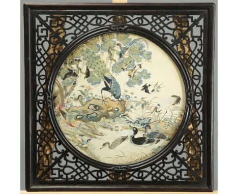 A 19TH CENTURY CHINESE SILK EMBROIDERY, circular, in a pierced hardwood frame. Overall 45cm by 45cmThe absence of a Condition