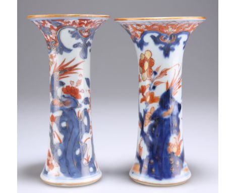 A NEAR PAIR OF 18TH CENTURY CHINESE IMARI GU VASES, each painted in the characteristic palette and gilded with foliage and a 